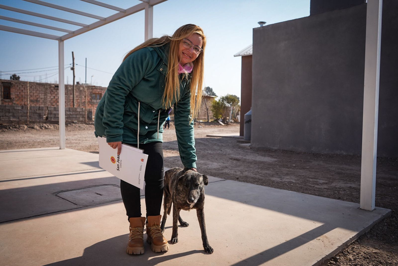 La Negra junto a su nueva dueña, Paula, quien adoptó a la perrita ni bien llegó al barrio.