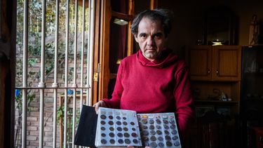 Cristian Rubia muestra parte de su colección de monedas en el salón de su casa.