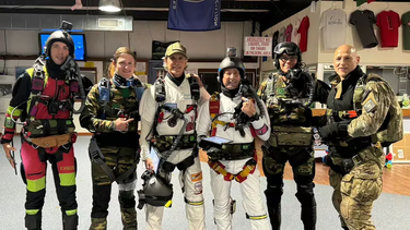 Marcelo Vives y Alejandro Montagna, los paracaidistas argentinos de blanco que lograron un récord de salto nocturno, junto al resto del equipo.