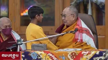 El Dalai Lama, junto al pequeño que se acercó para saludarle.