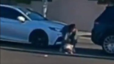 Captura de imagen del momento en el que la madre levanta al bebé que acababa de caerse de la camioneta.