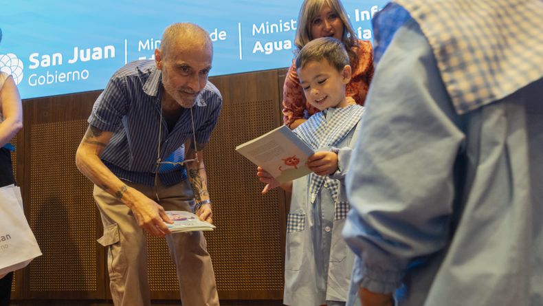 Pez entregando los libros de Obras Sanitarias a los niños de San Juan. 