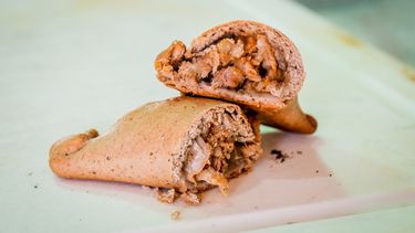 Empanada de chivo con masa de algarroba, un viaje de sabor autóctono imperdible.