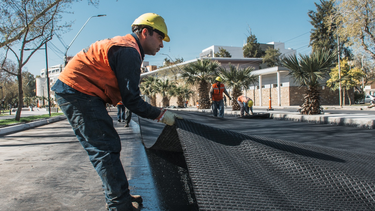 Los trabajadores deben avanzar paso a paso, meticulosamente y de modo manual para colocar las geogrillas sobre la Avenida Libertador.